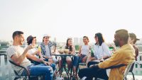 Friends enjoying drinks and snacks on a rooftop.