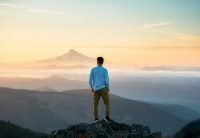man standing on top of mountain