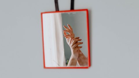 person holding red and white frame